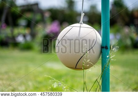 Tetherball Sitting Idle Next To The Pole In A Backyard.