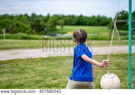Tetherball Being Hit And Roped In A Game With A Young Boy.