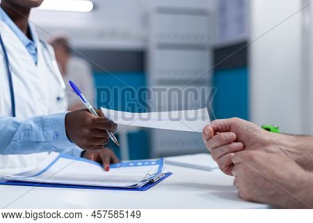 Close Up Of Clinic Specialist Medic Handing Over Analysis Report And Consultation Result To Senior P