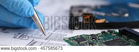 Close-up Of Male Fill Information In Papers With Silver Pen Wearing Gloves. Computer Details On Desk