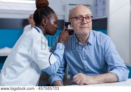 Clinic Otology Specialist Consulting Senior Patient Using Otoscope To Check Ear Infection. Hospital 