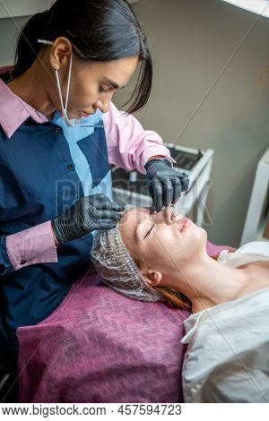 Permanent Makeup Cosmetologist Master Takes Measurements For The New Shape Of The Eyebrows Of Model.