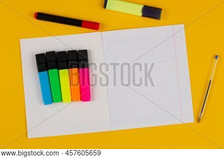 School Notebook On A Yellow Background With Copy Space For Text, Colorful Markers, English Alphabet.