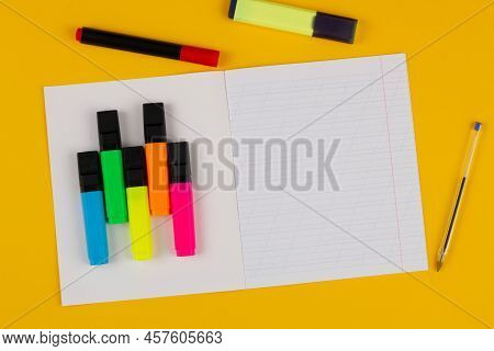 School Notebook On A Yellow Background With Copy Space For Text, Colorful Markers, English Alphabet.