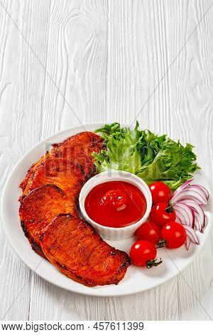Grilled Slices Of Pork Loin Marinated In Paprika Based Sauce With Tomatoes And Lettuce, Red Onion On