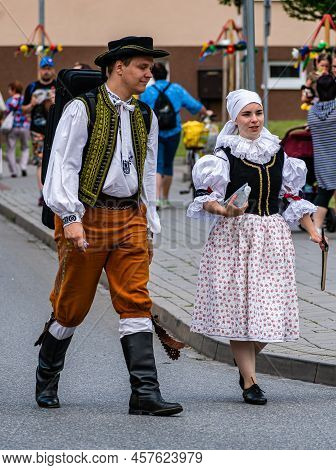 A Woman And A Man In Folk Costumes Talk To Each Other