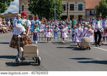 Children And Women With Strollers In Traditional Costumes