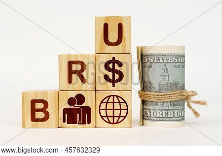 Business Concept. On A White Surface, Dollars And Cubes With Images And The Inscription - Bru
