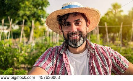 Portrait Of Modern Bearded Farmer Man Take Break With Hoe In Agricultural Field