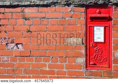 Prestatyn, Uk. Jun 22, 2022. A Red Postbox Mounted In A Brick Wall