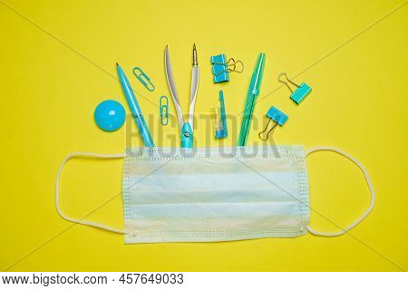 Shutdown Or Closed Carenavirus School Concept With Personal Mask, Stationery On Yellow Background Sc