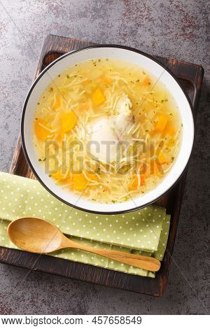 Chicken Broth With Noodles And Vegetables Close-up In A Plate On A Wooden Tray. Vertical Top View Fr
