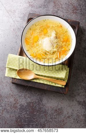 Light Chicken Soup With Pasta And Vegetables Close-up In A Bowl On A Wooden Tray On The Table. Verti