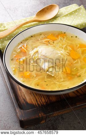 Chicken Broth With Noodles And Vegetables Close-up In A Plate On A Wooden Tray. Vertical