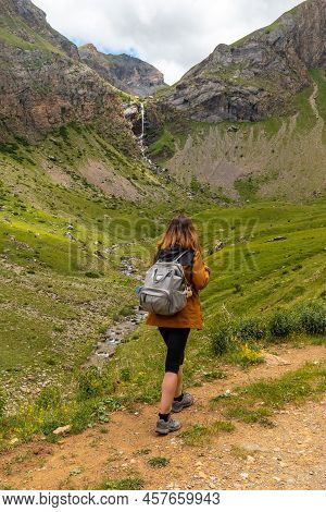 A Young Woman Next To The Salto De Tendenera Waterfall In The Ripera Valley, Panticosa, Pyrenees