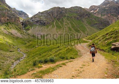 A Young Woman Next To The Salto De Tendenera Waterfall In The Ripera Valley, Panticosa, Pyrenees