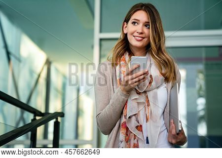 Outdoors Portrait Of Beautiful Young Business, Student Woman Laughing And Using Cell Phone