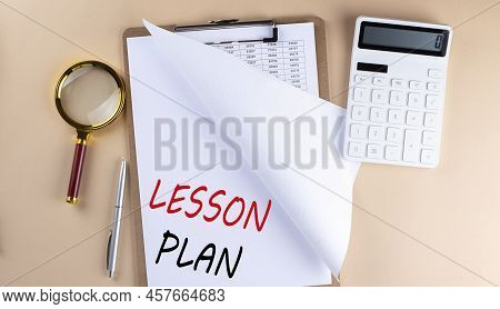 Clipboard With Chart And Text Lesson Plan With Magnifier ,calculator On A Beige Background
