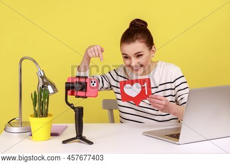 Happy Woman Blogger In Striped Shirt Recording Video For Followers Holding Like Sign, Asking To Rate