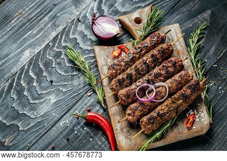 Shish Kebab On A Stick, From Ground Beef Meat On The Black Background. Chopping Board. Lula Kebab, T