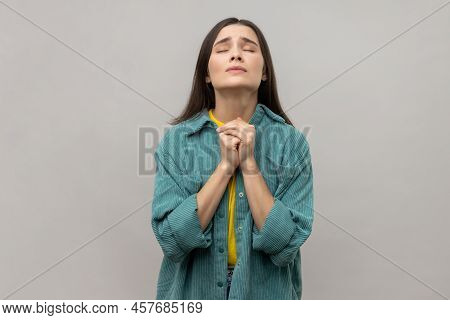 Portrait Of Pleading Young Adult Woman Looking Up With Hands In Prayer, Sincere Saying Please, Apolo