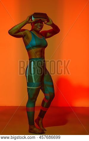 Modern African Black Woman With Short Hiar In Sport Top Wearing Glasses Of Virtual Reality On Yellow