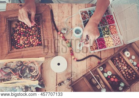 Top View Of Colorful Beads For Necklace And Bracelet And Woman Working On It To Do Trendy Jewels - P