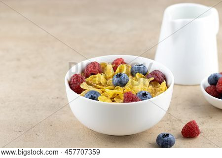 Delicious Golden Corn Flakes In A Bowl With Berries, Milk On A Beige Background. Side View, Copy Spa