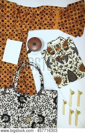 Flat Lay Batik Clotes With Canting, Small Pan And Wax Earthenware Glass Isolated On White Background