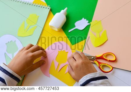 A Small Child Makes Paper Crafts For Mother's Day Or Birthday. A Small Child Makes Paper Flowers For