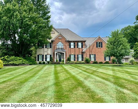 Lancaster, Pennsylvania - July 6, 2022: A Nicely Striped Mown Green Lawn With A House In The Backgro