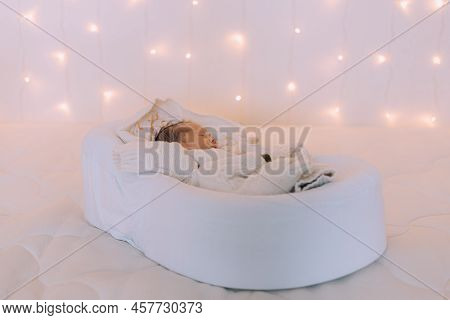 The Baby Is Lying In A Cocoon Of Copy Space . The Baby Is 0-3 Months Old. A Contented Infant. An Art