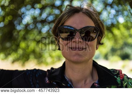 Picture Of A Relaxed Attractive Woman In The Shadows Of A Tree, Kordel, Germany