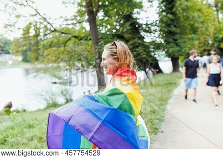 Happy Young Blonde Hair Woman Covering With Lgbtqi Pride Rainbow Flag On The Street In The Park. Lgb