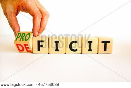 Proficit Or Deficit Symbol. Businessman Turns Wooden Cubes And Changes The Concept Word Deficit To P
