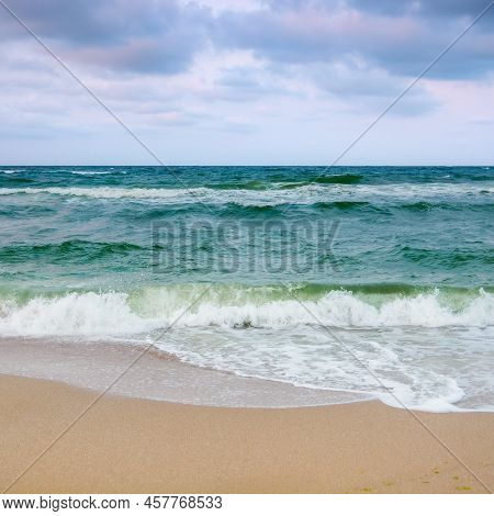 Sandy Beach Before The Storm. Evening Scenery With Heavy Clouds In Colorful Light. Turquoise Waves R