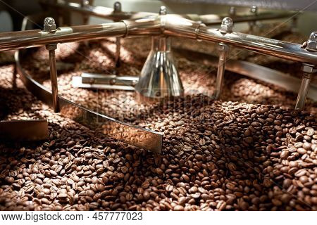 Natural Roasted Coffee Beans Mixing In Mixer Of Industrial Roasting Machine On Factory. Coffee Proce