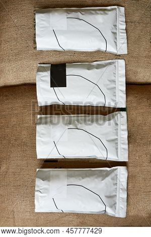 Top View Of Row Of Variety Coffee Packages Lying On Textile Sack With Fresh Organic Natural Coffee B