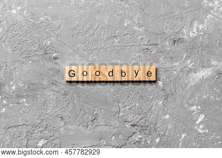 Goodbye Word Written On Wood Block. Goodbye Text On Table, Concept.
