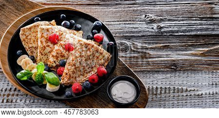 A Plate Of Pancakes With Cheese And Fruits
