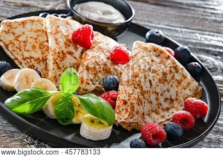 A Plate Of Pancakes With Cheese And Fruits
