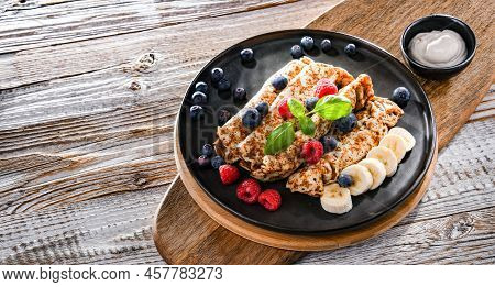 A Plate Of Pancakes With Cheese And Fruits