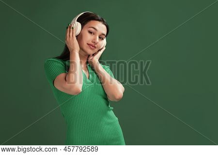 Portrait Of Attractive Young Girl Listening To Music In Headphones, Enjoying, Posing Isolated Over G
