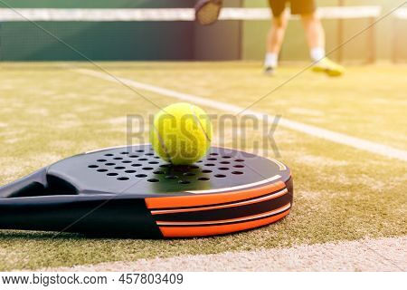One Caucasian Mature Man Playing Behind Net With Yellow Ball Over A Padel Racket