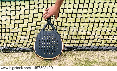 Professional Monitor Of Padel Holding Black Racket Behind The Net. Game Concept