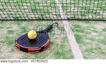 Yellow Ball Over Padel Tennis Racket Behind Net In Green Court Outdoors