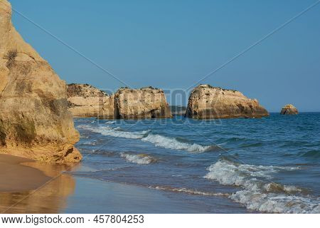 Limestone Rocks Washed By The Ocean On The Praia Dos Tres Castelos In Portimao, Portugal
