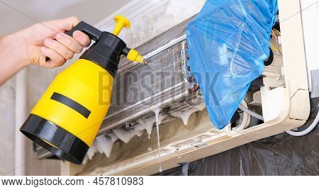 A Man Washes Off A Special Foam For Cleaning Air Conditioners With A Jet Of Water Under Pressure. Sp