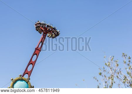 Russia, Sochi 14.05.2022. Rotating Round Extreme Attraction With People Against The Blue Sky In An A