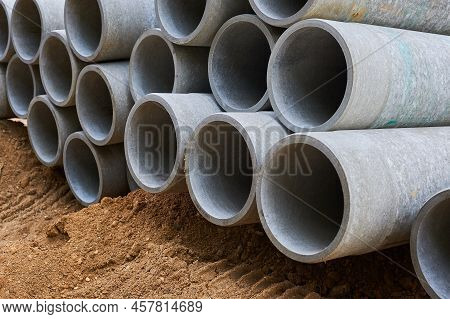 Concrete Pipes To Replace The City Sewer System Are Lying On The Sand And Ready For Installation.